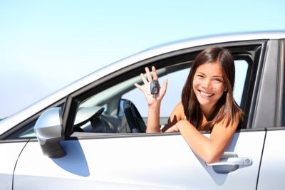 teenage girl behind the wheel of a car